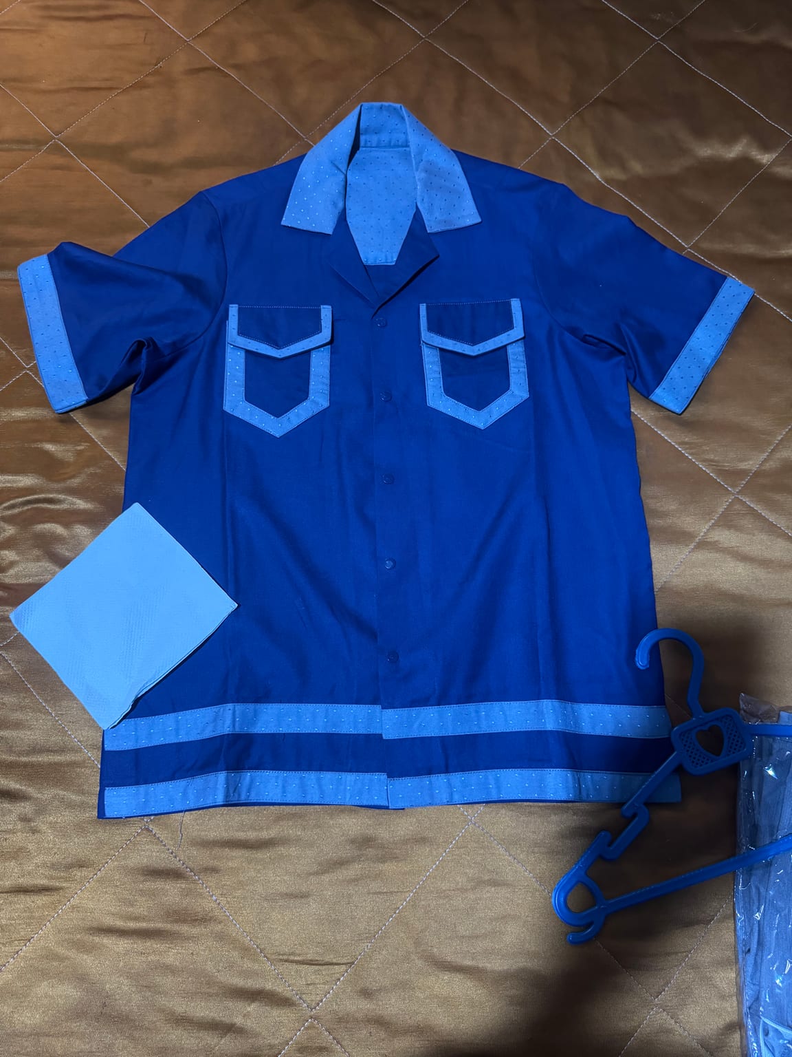 Contrasting light blue collar and pocket flaps with polka dots.